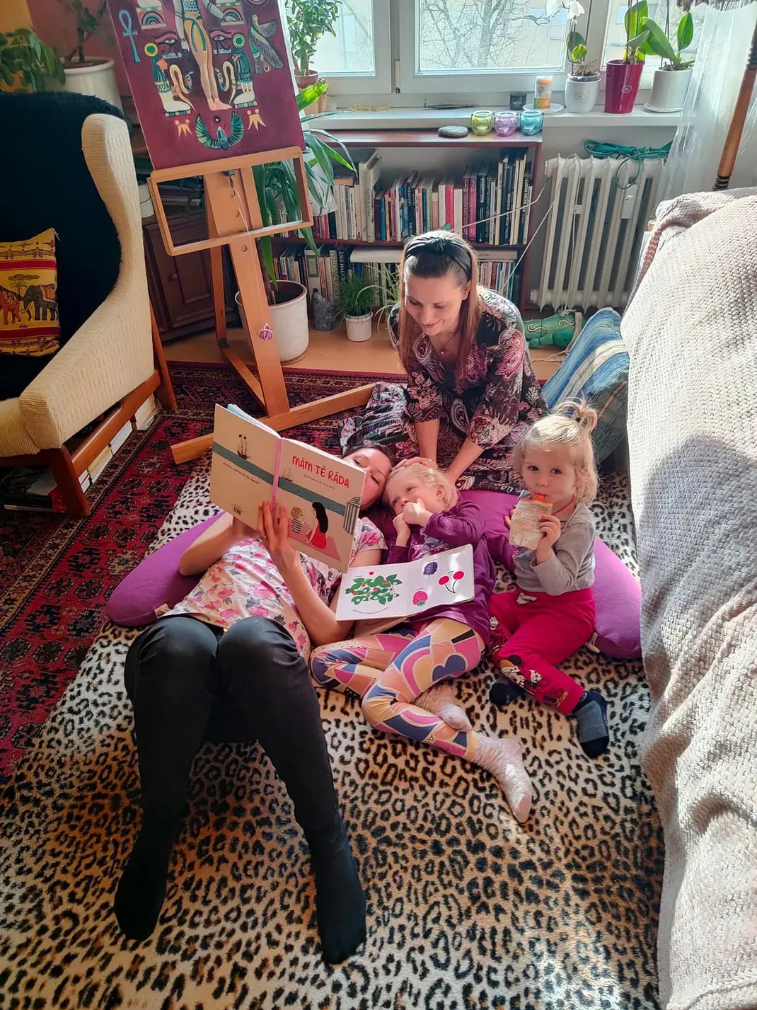 Lenka Lorien applying craniosacral therapy to the kid with sibling and mother